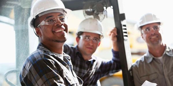 three skilled workers standing and smiling
